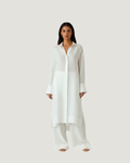 Woman wearing a long white shirt and pants on a light background ishq e amore linen white 