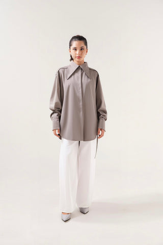 Person wearing a gray shirt and white pants on a white background
