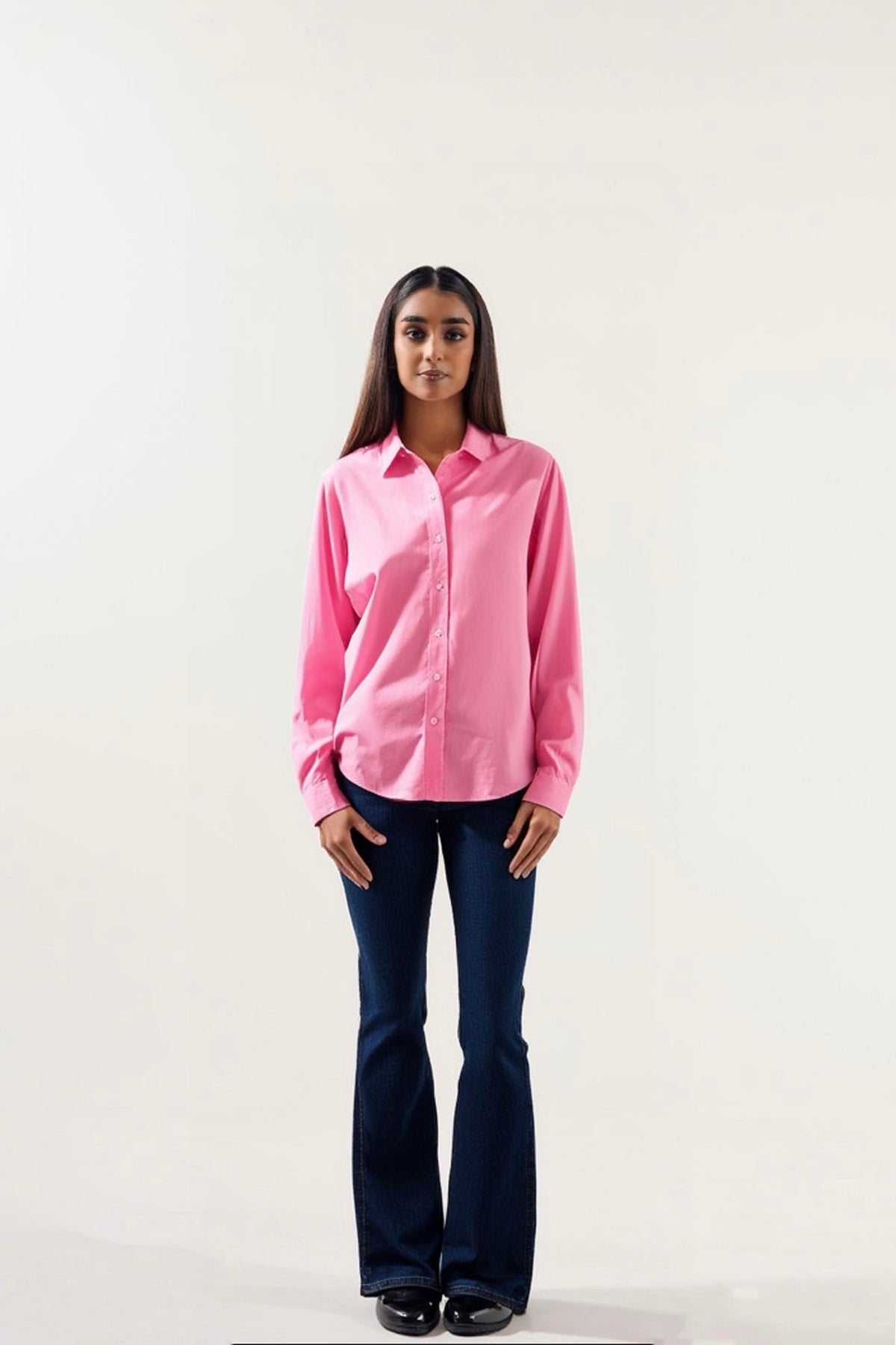 Woman wearing a pink shirt and blue jeans on a white background