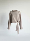 Beige long-sleeve top with a tie detail on a light gray background ishq e amore asymmetrical top 